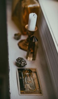 a candle and some other items sitting on a window sill