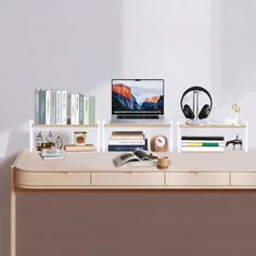 a desk with a laptop, headphones and books on it