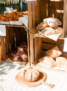 breads and pastries are displayed on wooden crates