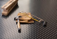 tools are laying on the floor next to some wood planks and a piece of cloth