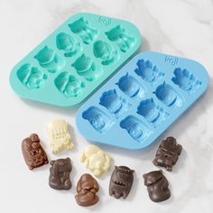 an ice tray filled with chocolates next to some molding moulders on a marble surface