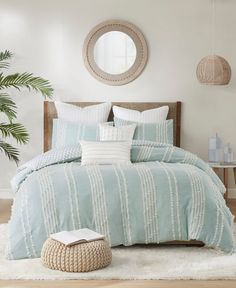 a bed in a bedroom with blue and white comforter, pillows and rugs