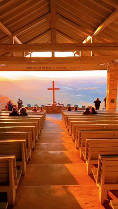 people are sitting at the alters in front of a cross on top of a hill