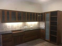 an empty kitchen with wooden cabinets and tile backsplash