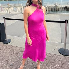 a woman in a pink dress posing for the camera with her hand on her hip