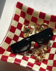 a red and white checkered tray with some black sunglasses on it