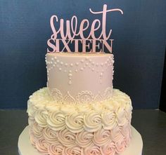 a pink and white cake with the word sweet sixteen on top