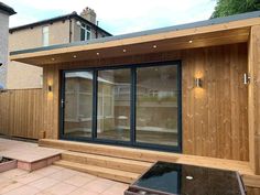 a wooden building with sliding glass doors on the outside