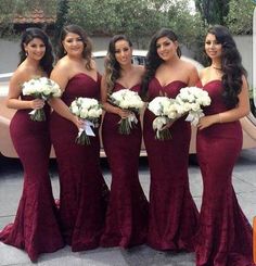 the bridesmaids are posing for a photo in front of a car with their bouquets