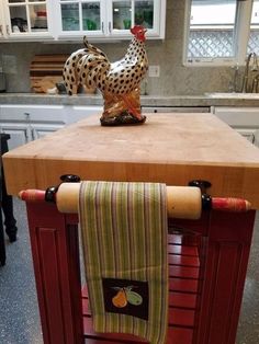 a kitchen island with a towel on it and a rooster figurine sitting on top