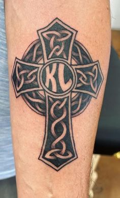 a cross tattoo with the letter k on it