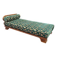 a green and gold patterned couch with wooden legs