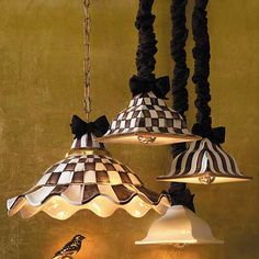 three lamps hanging from the ceiling with black and white checkerboard shades on them