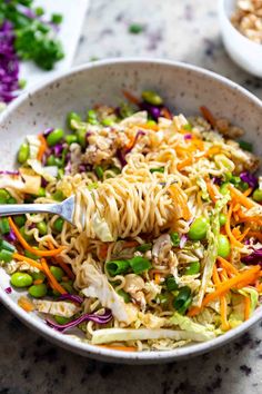 a white bowl filled with noodles and vegetables