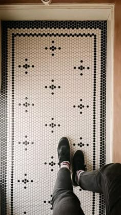 a person standing in front of a wall with black and white designs