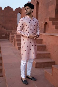 Powder pink kurta with maroon thread floral embroidery and front buttons. Paired with contrast pant.
Components: 2
Pattern: Embroidered
Type Of Work: Floral
Neckline: Mandarin
Sleeve Type: Full
Fabric: Chanderi silk
Color: Pink
Other Details: 
Front buttons
Embroidered kurta
Occasion: Wedding - Aza Fashions Pink Embroidered Cotton Silk Churidar, Festive Pink Bandhgala With Floral Embroidery, Traditional Pink Cotton Silk Kurta, Designer Sherwani With Floral Embroidery For Navratri, Pink Churidar With Floral Embroidery For Navratri, Bollywood Cotton Bandhgala With Floral Embroidery, Floral Embroidered Sherwani For Eid, Eid Sherwani With Floral Embroidery, Pink Floral Embroidered Churidar For Navratri