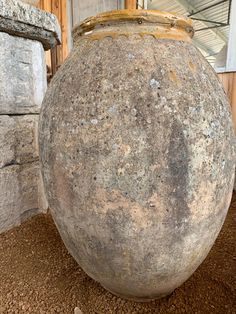 a large stone vase sitting on top of a dirt ground