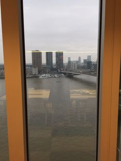 an open window with a view of a river and buildings in the distance from it