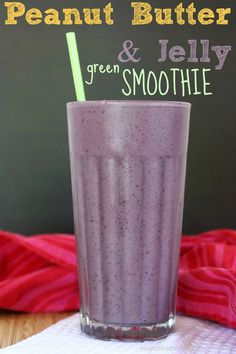 a purple smoothie in a tall glass with a green straw on the top and text overlay that reads, peanut butter & tell green smoothie