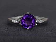 Welcome to my shop, you can find many beautiful gemstone jewelry here, and you also can ask for customized service. Main Stone: natural amethyst, round cut 7X7mm, weighs about 1.24 caratsAccent Stones: czMetal: 925 sterling silver plated with rhodium. I also can provide metal options such as 14k solid yellow/white/rose goldSetting: prong settingmore rings: https://www.etsy.com/shop/XCjewelryStudio?ref=hdr_shop_menuIt's quite comfortable for wearing and suitable for all occasions (wedding, annive Classic Purple Amethyst Ring With Round Cut, Classic Purple Amethyst Round Cut Ring, Classic Purple Amethyst Ring Round Cut, Classic Amethyst Round Cut Birthstone Ring, Classic Amethyst Birthstone Ring With Round Cut, Purple Amethyst Ring With Center Round Stone, Purple Amethyst Ring With Center Stone, Purple Round Cut Birthstone Ring Fine Jewelry, Brilliant Cut Amethyst Ring As Gift