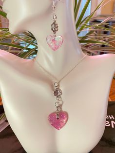 a white mannequin with two heart shaped necklaces hanging from it's neck