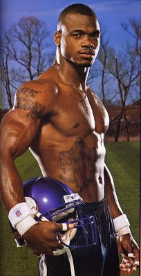 a man with no shirt holding a football