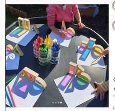 two children are sitting at a table with paper and colored crayons on it