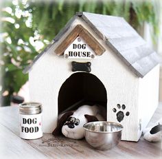 a dog house that is on top of a table next to some bowls and food