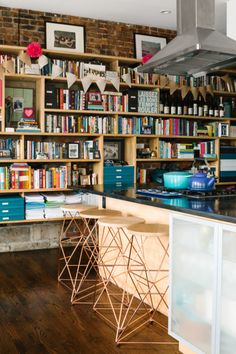 a kitchen with lots of bookshelves and cabinets in the back ground, next to a stove top oven