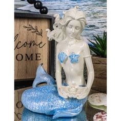 a statue of a mermaid sitting on top of a table