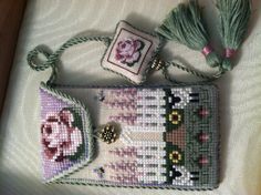 a cross stitch purse with a tassel on it