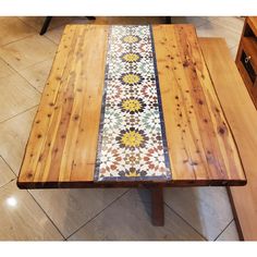 the table is made from wood and has a multicolored tile design on it