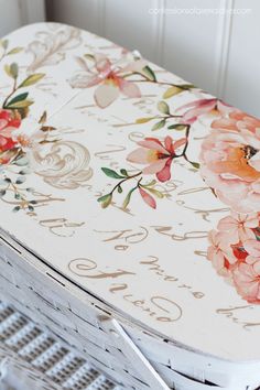 an old wooden box with flowers painted on the top and bottom, sitting on a table