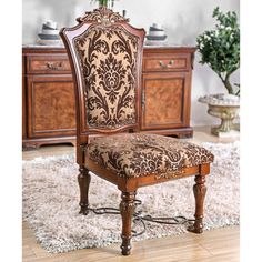 an ornately decorated chair sits in front of a dresser