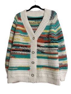 a white sweater with multicolored stripes on the front and back, hanging from a hanger