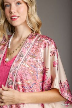 The Satin Breeze Border Print Kimono is an elegant and lightweight layering piece that adds a touch of sophistication to any outfit. Crafted from 100% polyester, this kimono features a smooth, silky satin finish that drapes beautifully over the body. The open front design allows for effortless styling, while the intricate border print adds a touch of artistry and visual interest. Short sleeves make it perfect for warmer weather, and the flowy silhouette enhances its relaxed, bohemian vibe. Fit & Elegant Floral Print V-neck Kimono, Elegant Open Front Kimono For Spring, Floral Print Satin Kimono, Satin Kimono With Floral Print, Elegant Wrap Kimono With Floral Print, Elegant Spring Kimono With Kimono Sleeves, Spring Satin Wrap Kimono, Elegant Satin Beach Kimono, Elegant Beach Satin Kimono