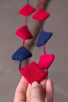 a hand is holding an ornament made out of knitted material