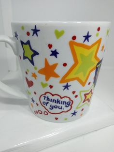 a white coffee cup with colorful stars on it