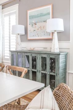 a dining room table with two lamps on top of it