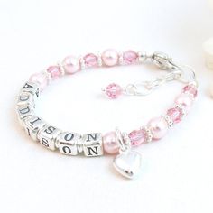 "Pink Pearl Beaded Name Bracelet for Infant, Baby, or Little Girl:  This custom personalized gift features rosaline 5mm round Swarovski® pearls, 4mm round light rose Swarovski® crystals, petite sterling silver alphabet beads, sterling silver bright daisy spacers, and a sterling silver heart-shaped lobster clasp with a 1/2\" \"Grow with Me\" extender chain. The beads are strung on super strong, stainless-steel wire for extra durability. Choose one sterling silver charm:  Cross, Star of David, Puffed Heart, or Butterfly All metal components are sterling silver. Arrives packaged in my signature soft fabric gift bag.  B R A C E L E T . S I Z I N G . G U I D E  For a perfect fit, the bracelet should be 3/4\" larger than her snug wrist measurement.  If you are unable to measure, you may use this Personalized Pink Charm Bracelet For Birthday, Customizable Pink Charm Bracelet For Birthday, Mother's Day Pink Name Bracelet, Personalized Pink Round Bead Name Bracelet, Personalized Pink Name Bracelet With Round Beads, Pink Name Bracelet For Birthday, Personalized Name Bracelet In Pink, Personalized Pink Name Bracelets, Custom Name Pink Name Bracelet For Gift