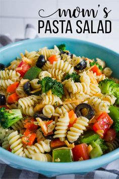 a blue bowl filled with pasta and vegetables