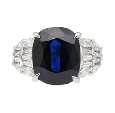 A stunning platinum ring presenting a 7.25 CT cushion-cut sapphire. The gems mesmerizing deep shade of blue catches the eye of any who come across it. The sapphire is accompanied by 10 tapered baguette-cut diamonds as well as 8 marquise-cut diamonds along the sides. Both gems complement each other well, due to the high contrast between the two. This ring weighs a total of 10.21 grams. Size 7 3/4 and adjustable.    Details:  Item Type:  Engagement Ring Metal: Platinum 900 Size: 7 3/4 (adjustable) Luxury Sapphire Baguette Cut Ring, Luxury Sapphire Ring With Brilliant And Baguette Cuts, Luxury Gia Certified Baguette Cut Sapphire Ring, Luxury Platinum Baguette Cut Sapphire Ring, Luxury Octagon Brilliant Cut Sapphire Ring, Luxury Octagon Sapphire Ring With Brilliant Cut, Luxury Platinum Octagon Sapphire Ring, Luxury Octagon Sapphire Ring In Platinum, Luxury Octagon Sapphire Platinum Ring