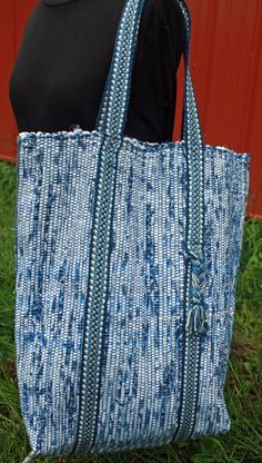 Handwoven blue and white tote bag.  This bag is woven with cotton warp threads and cotton fabric weft in the tradition of rag rugs.  The double straps are woven to match on an inkle loom and have a cute braided detail on one side.  The straps add support to the bottom of the bag and have a 9 inch drop.  The dimensions are 12 inches wide by 17 inches high by 5 inches deep giving plenty of room to stow all your gear for shopping, travel, the library or the beach.  Two interior pockets help keep things organized.  A 10 inch x 9 inch pocket secures with velcro and a 5 x 5 pocket is open for easy access to your phone or keys. I do my best to represent the colors accurately, but every monitor is different.  If in doubt about a color, please ask for a sample swatch. Blue Handwoven Shoulder Bag For Market, Eco-friendly Handwoven Blue Shoulder Bag, Eco-friendly Blue Handwoven Shoulder Bag, Blue Handwoven Tote Shoulder Bag, Decorated Tote Bags, Wool Tote, Inkle Loom, Rag Rugs, White Tote Bag