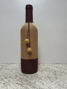 a bottle with two balls attached to it sitting on a counter top next to a wall