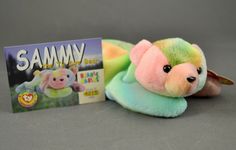 a stuffed animal next to a book on a gray surface with an image of a pig