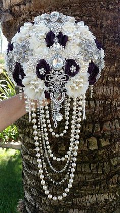 the bridal bouquet is adorned with pearls and flowers, which are attached to a palm tree