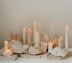 some white candles sitting on top of rocks