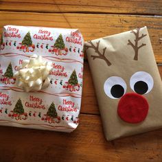 two wrapped presents are sitting on the floor next to each other, decorated like santa's face