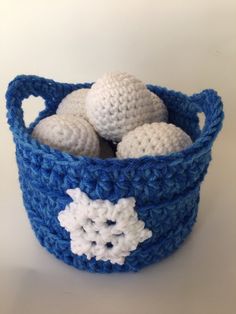 a crocheted basket with balls in it