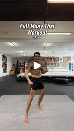 a man standing on top of a mat in a gym